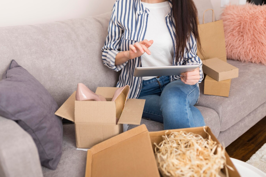 Woman exploring affordable subscription box alternatives while unboxing packages and shopping online from home.