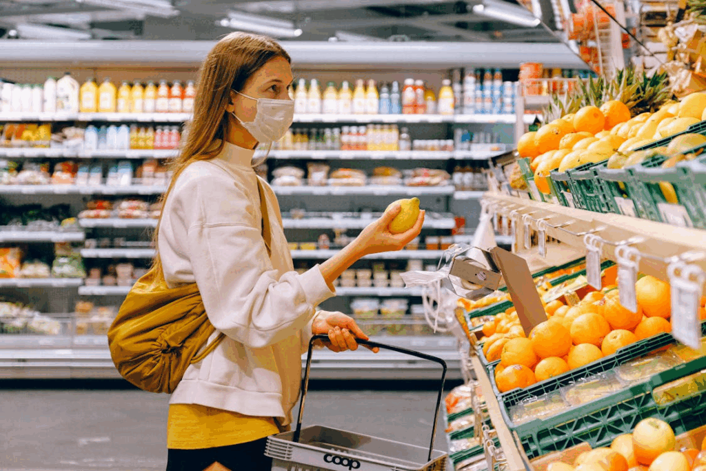 Woman shopping for fresh produce using smart strategies to cut grocery costs without coupons.